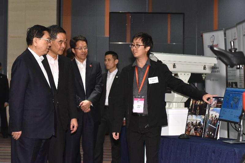 全国人大常委会委员长张德江（左一）今日（五月十八日）在香港科学园与一名本地创科初创青年企业家交谈，聆听他介绍一座结合不同机械人技术而制成的防火机械人。旁为行政长官梁振英（左二）和中央人民政府驻香港特别行政区联络办公室主任张晓明（左三）。