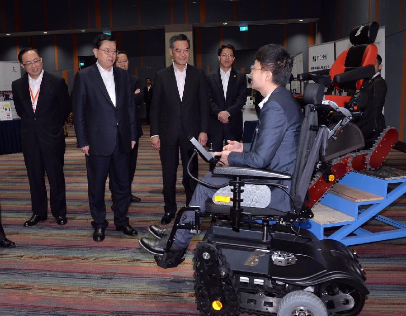 一间本地创科初创企业代表今日（五月十八日）在香港科学园向全国人大常委会委员长张德江（左二）介绍多功能电动轮椅。旁为行政长官梁振英（中）、中央人民政府驻香港特别行政区联络办公室主任张晓明（右二）和创新及科技局局长杨伟雄（左一）。