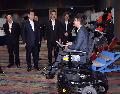 一间本地创科初创企业代表今日（五月十八日）在香港科学园向全国人大常委会委员长张德江（左二）介绍多功能电动轮椅。旁为行政长官梁振英（中）、中央人民政府驻香港特别行政区联络办公室主任张晓明（右二）和创新及科技局局长杨伟雄（左一）。