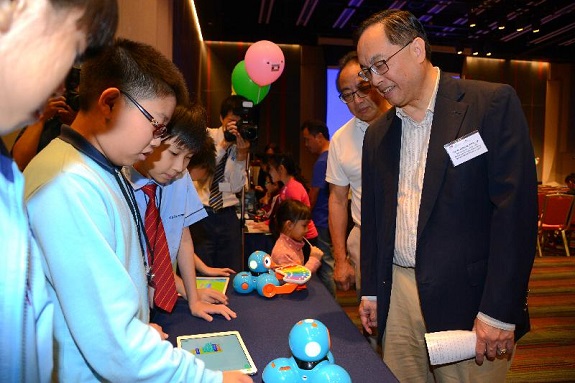 乐善堂梁黄蕙芳纪念学校的学生今日（十二月四日）在「编程一小时」香港区两周年典礼上，向创新及科技局局长杨伟雄（右）展示作品。乐善堂梁黄蕙芳纪念学校是「编程一小时」香港区活动其中一个参与机构。 