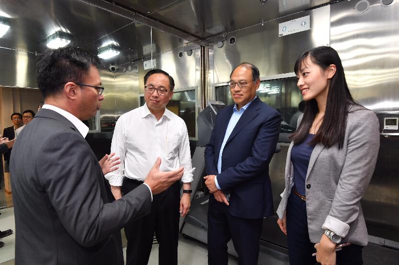 創新及科技局局長楊偉雄（左二）今日（九月十八日）在香港體育學院（體院）董事局主席林大輝（右二）陪同下，聽取體院精英訓練科技總監蘇志雄博士（左一）講述體院以模擬環境倉進行賽前預備訓練，讓運動員適應在相對較濕較熱的環境下作賽，運動員也可在倉內模擬的海拔高度下進行加量訓練。