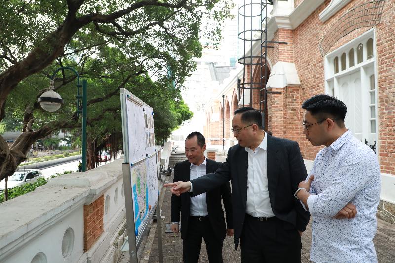 The Secretary for Innovation and Technology, Mr Nicholas W Yang (centre), receives a briefing by the Assistant Government Chief Information Officer (Industry Development), Mr Tony Wong (left), on the Smart Lampposts pilot scheme, and inspects a proposed section along Nathan Road where such lampposts will be installed, during his visit to Yau Tsim Mong District today (March 26). Next to Mr Yang is the Chairman of the Yau Tsim Mong District Council, Mr Chris Ip (right).