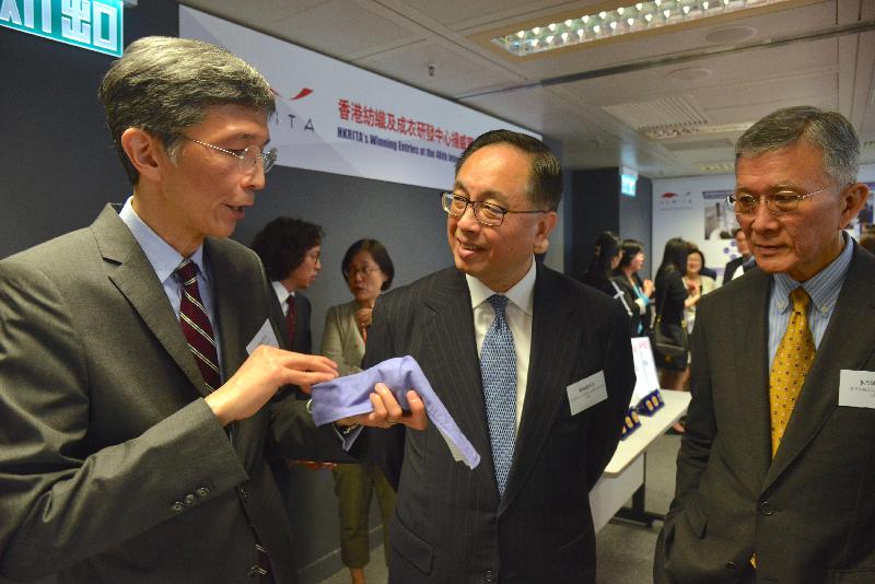 創新及科技局局長楊偉雄（中）今日（四月十九日）聽取香港紡織及成衣研發中心行政總裁葛儀文（左）介紹用以應對空氣污染的可水洗衞生口罩。該發明在第46屆日內瓦國際發明展榮獲金獎。