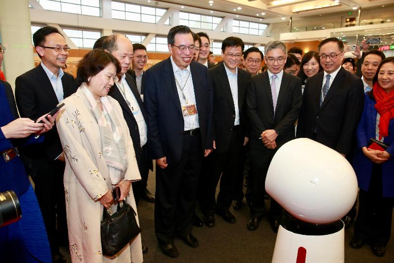 The Secretary for Constitutional and Mainland Affairs, Mr Patrick Nip (first left); the Secretary for Innovation and Technology, Mr Nicholas W Yang (front row, second right); the Secretary for Financial Services and the Treasury, Mr James Lau (front row, third right), and Legislative Council members today (April 22) visited the Shanghai Stock Exchange (SSE) to learn more about the development of the financial industry of Shanghai. Picture shows SSE’s artificially intelligent robotic staff “Zhenzhen” (bottom right) interacting with the delegation.