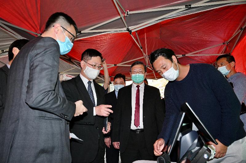 The Secretary for Innovation and Technology, Mr Alfred Sit (second left), today (February 4) receives a briefing on footfall monitoring at points of sale of New Year flowers by the Director of Electrical and Mechanical Services, Mr Pang Yiu-hung (second right), at Victoria Park.