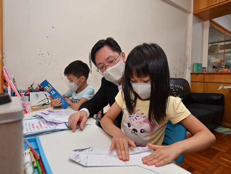 The Secretary for Innovation and Technology, Mr Alfred Sit (centre), today (July 1) visits a family with twins living in a sublet unit during a community care activity organised by the Hong Kong Technology and Innovation Volunteers Alliance in Kwun Tong in celebration of the 100th anniversary of the founding of the Communist Party of China and the 24th anniversary of the establishment of the Hong Kong Special Administrative Region. 
