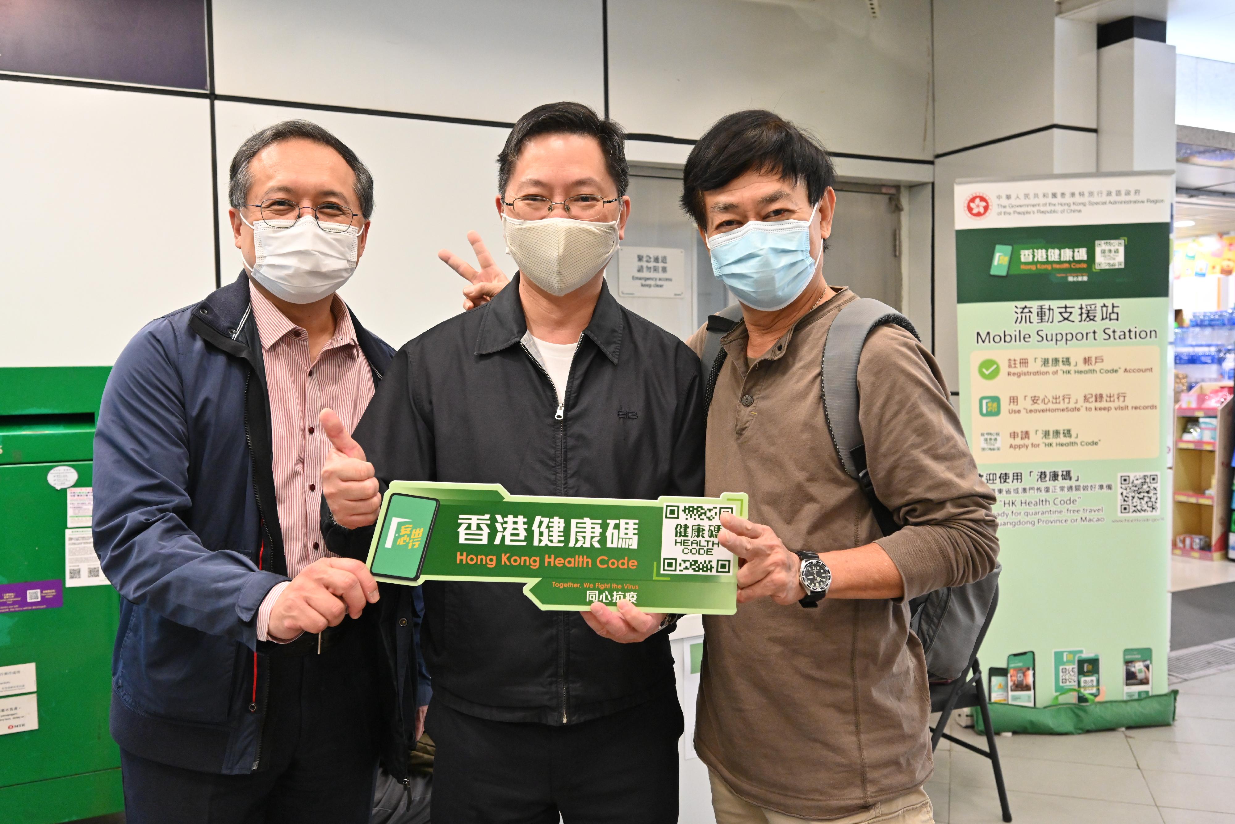 The Secretary for Innovation and Technology, Mr Alfred Sit (centre), today (December 25) views the operation of the Hong Kong Health Code mobile support station at Tai Po Market MTR Station and is pictured with a member of the public. Next to Mr Sit is the Assistant Government Chief Information Officer (Industry Development), Mr Kingsley Wong (left).