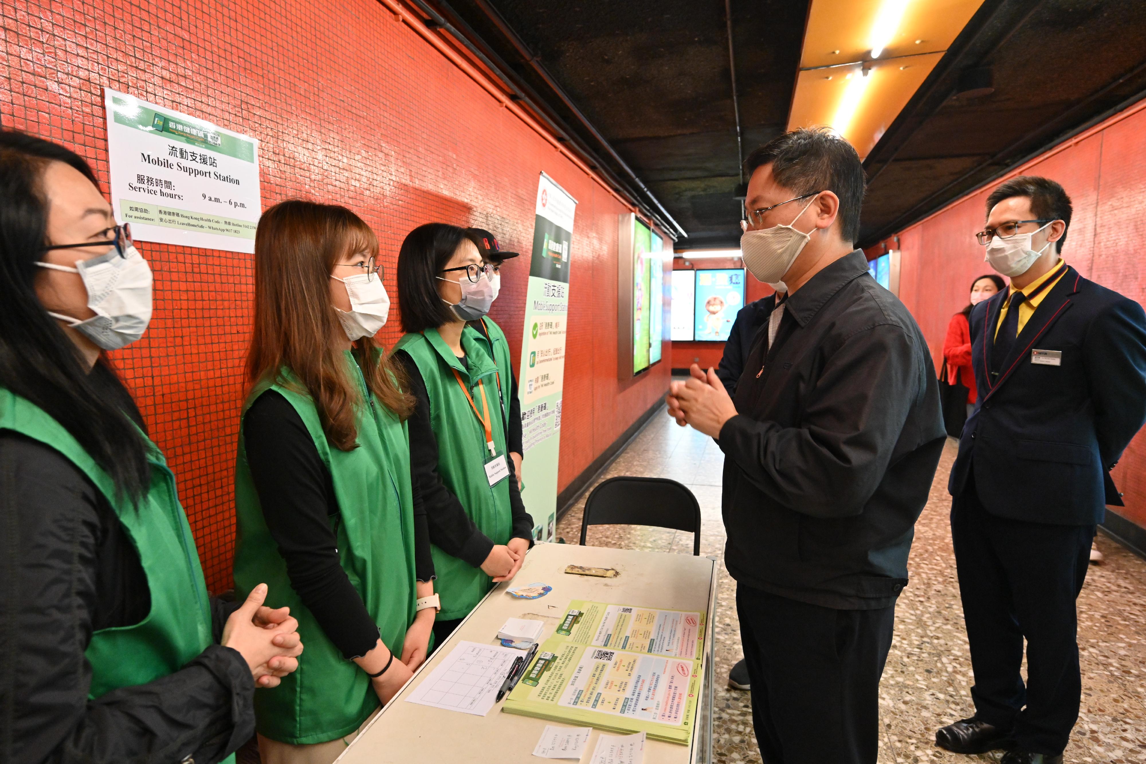 The Secretary for Innovation and Technology, Mr Alfred Sit (second right), visits the Hong Kong Health Code mobile support station located at North Point MTR Station today (December 25) to better understand how the outreach team assists citizens in need to make applications for the Hong Kong Health Code.