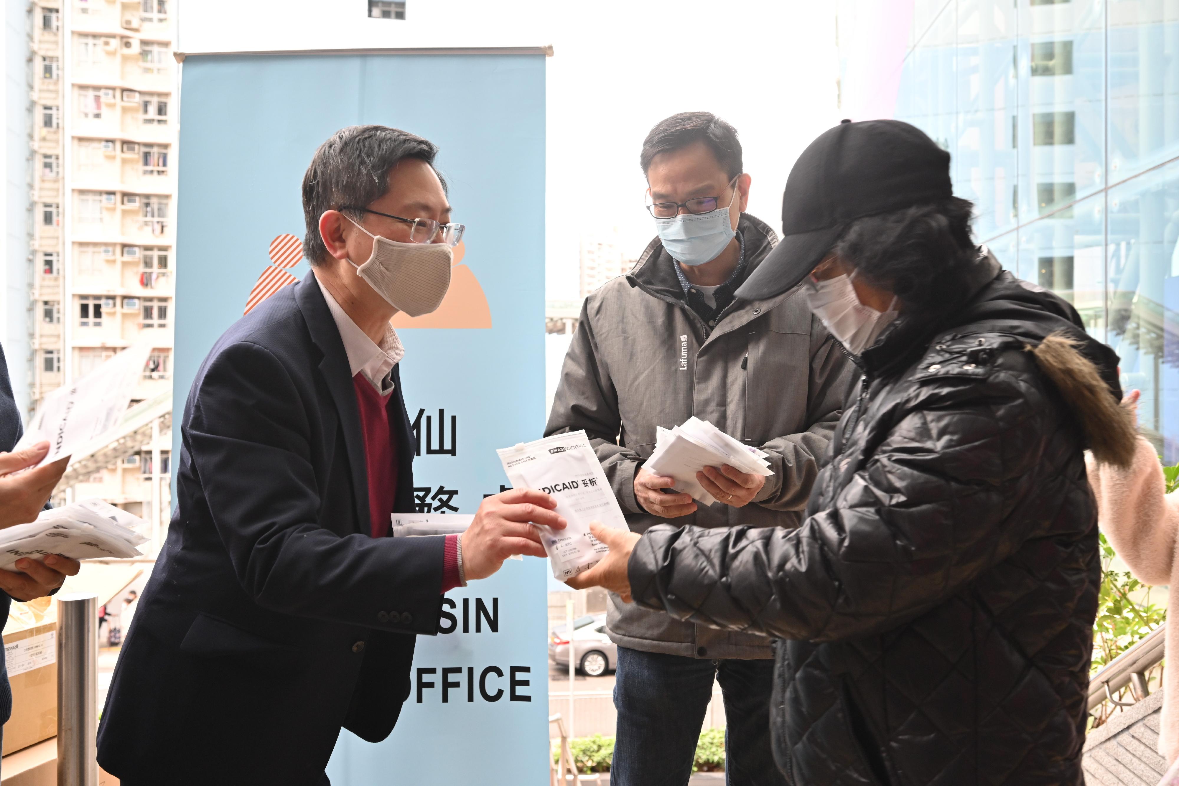 創新及科技局局長薛永恒（左一）今日（二月三日）到慈雲山中心向市民派發快速測試套裝，呼籲市民願檢盡檢，早日擊退疫情。