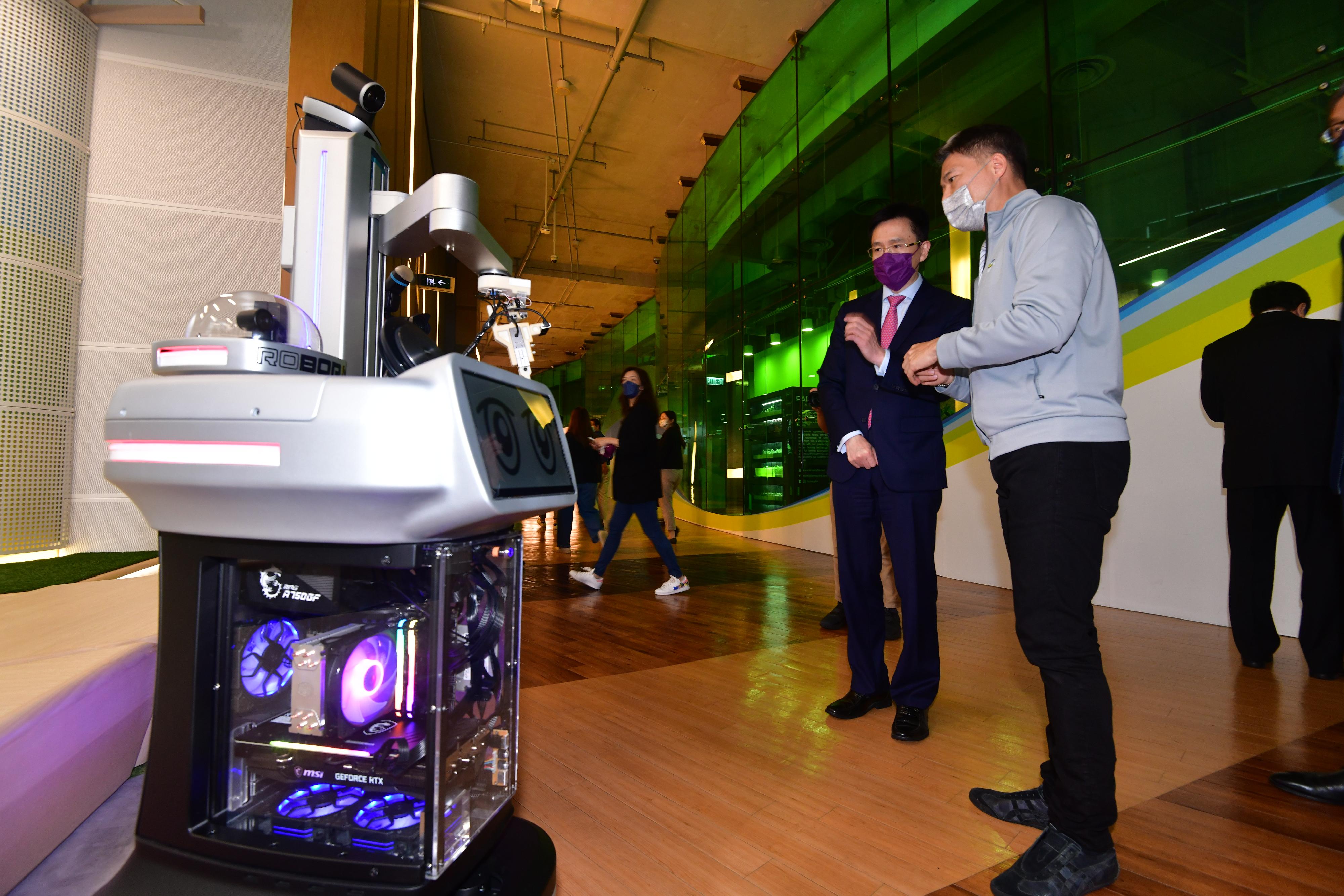 The Secretary for Innovation, Technology and Industry, Professor Sun Dong (left), exchanges views with a start-up entrepreneur during his visit to Cyberport today (July 5).