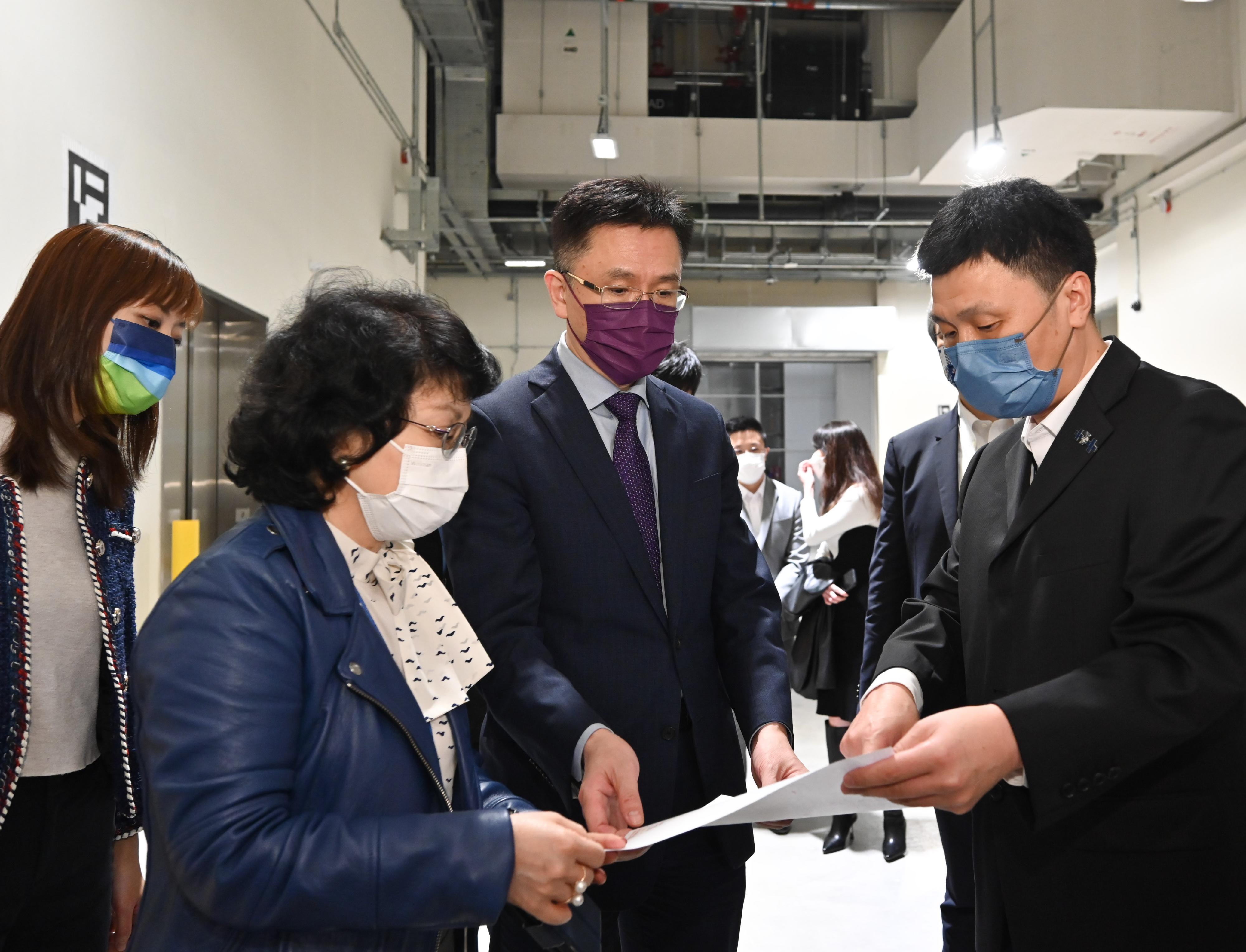 創新科技及工業局局長孫東教授（右二）今日（十二月一日）參觀一家已進駐先進製造業中心的企業，聽取有關商業航天衛星設計及製造的介紹。旁為創新科技及工業局副局長張曼莉（左一）。
