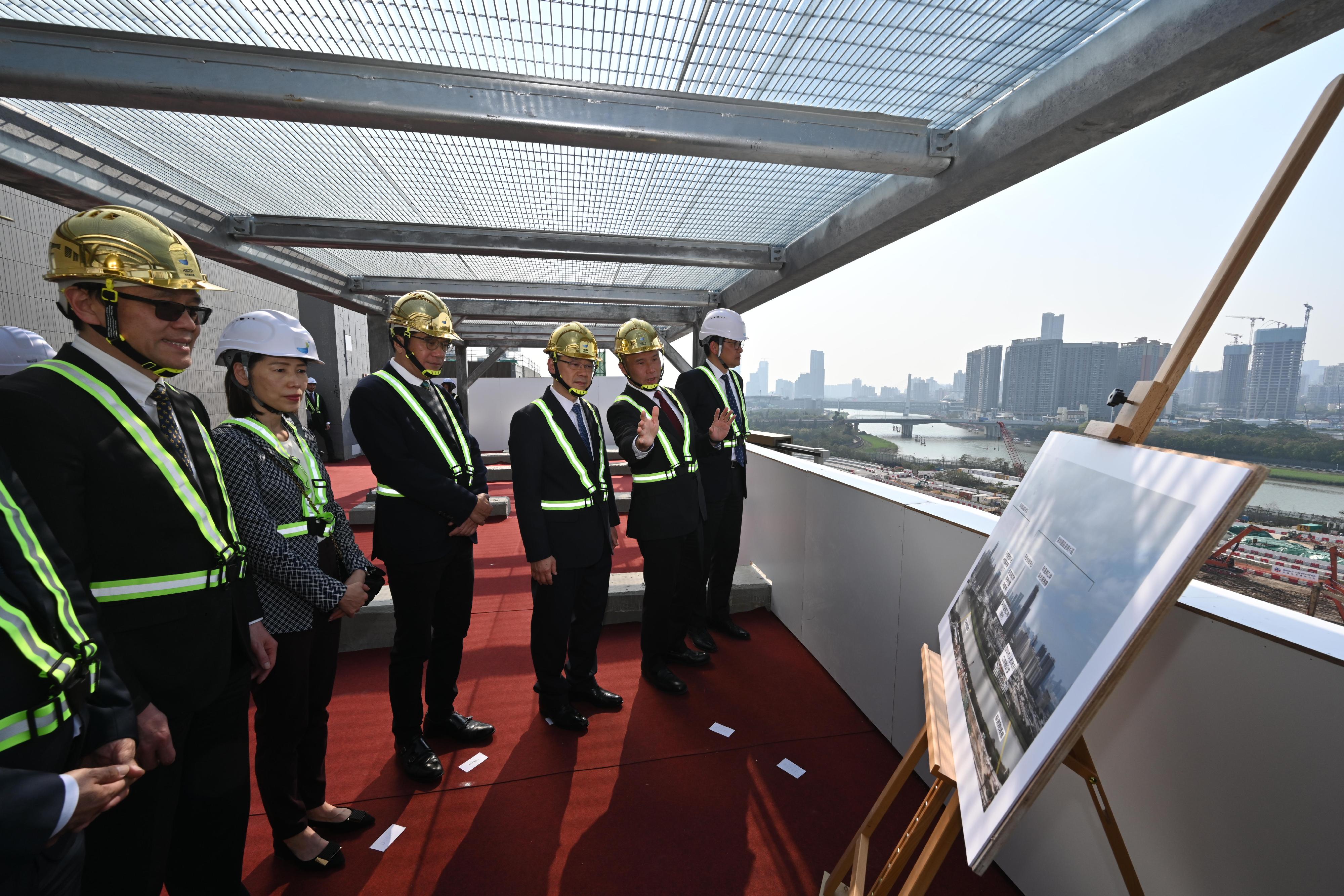 行政長官李家超今日（三月二十一日）出席港深創新及科技園8號及9號大樓平頂儀式。圖示李家超（右三）、署理財政司司長黃偉綸（左三）和創新科技及工業局局長孫東教授（左一）聽取港深創新及科技園有限公司行政總裁馬惟善（右二）介紹河套香港園區及深圳園區。